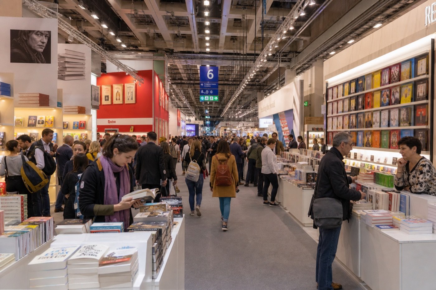 Busy international book fair exhibition hall with publisher booths and attendees